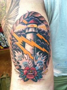 custom_traditional_rope_framed_lighthouse_in_storm_with_rose_and_crashing_waves_and_lightning_arm_tattoo_by_david_meek_tucson_arizona