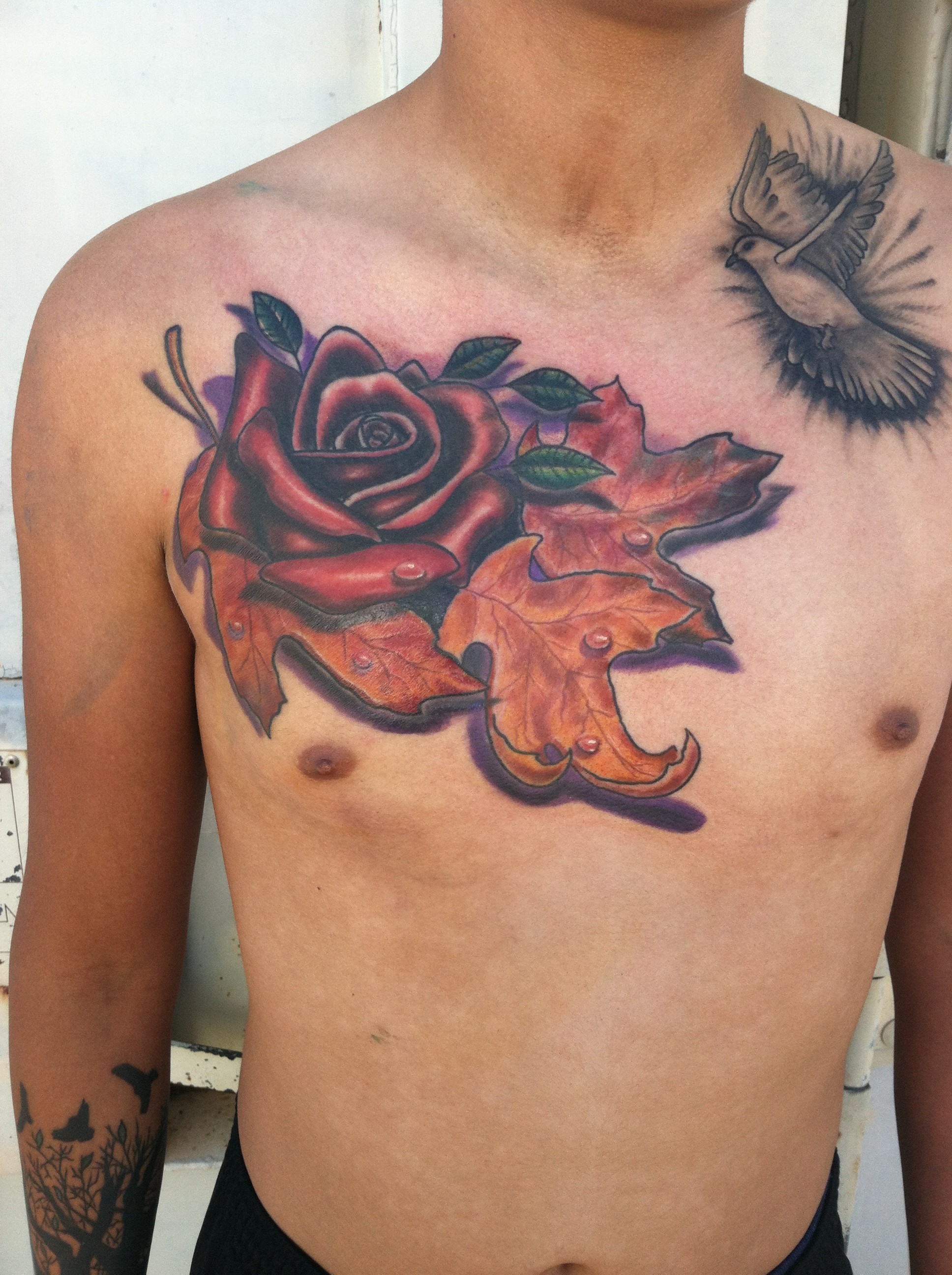 Tough masculine Rose and autumn fall leaves chest color tattoo by David Meek at Fast Lane Tattoo in Tucson Arizona