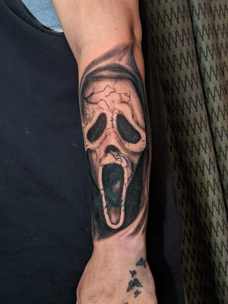 Black and Grey Realistic Horror movie Ghost Face Scream coverup tattoo by David Meek of Art and Sol Tattoo in Tucson Arizona